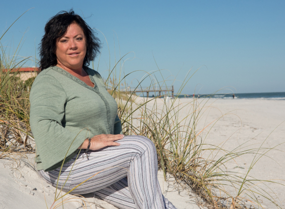 Dr. Deborah Evans sitting on a Florida coast beach.